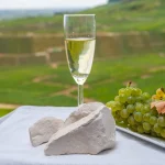 White chalk stones from Cote des Blancs near Epernay, region Champagne, France, glass of blanc de blancs champagne from grand cru vineyards in Cramant and white chardonnay grapes