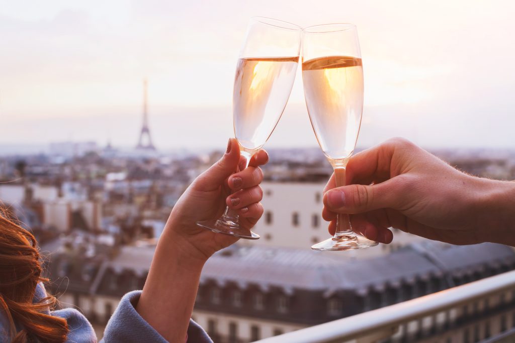 two glasses of champagne or wine, couple in Paris, romantic celebration of engagement or anniversary